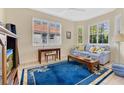 Cozy living room area featuring tile floors, a large window with shutters, and a comfortable blue sofa at 730 Foggy Morn Ln, Bradenton, FL 34212