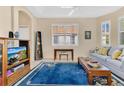 Inviting living room featuring tile floors, a large window with shutters and a comfortable blue sofa at 730 Foggy Morn Ln, Bradenton, FL 34212