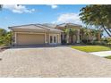 Paver driveway leading to charming single-story home with well-manicured lawn and an attached two-car garage at 742 Shadow Bay Way, Osprey, FL 34229