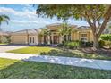 Attractive single-story home featuring manicured landscaping, a paver driveway, and a welcoming double-door entryway at 742 Shadow Bay Way, Osprey, FL 34229