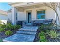 Inviting front porch with stone steps, comfortable seating, and well-maintained landscaping at 7712 Saloon Ln, Sarasota, FL 34240