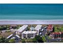 Aerial view of beachfront condos, a pool, and private beach access at 8767 Midnight Pass Rd # 403F, Sarasota, FL 34242
