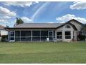 Rear exterior view featuring a screened lanai, lush backyard, and covered patio area at 4906 Peridia E Blvd, Bradenton, FL 34203