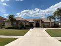 Lovely single-story home with a well-manicured lawn, mature palm trees, and circular entry at 4906 Peridia E Blvd, Bradenton, FL 34203