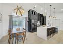 Stylish kitchen with black cabinets, stainless steel appliances, and an island with barstool seating at 7251 Sunnybrook Blvd, Englewood, FL 34224