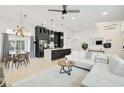 Open-concept living space with a white sofa, modern kitchen, and dining area at 7251 Sunnybrook Blvd, Englewood, FL 34224