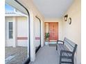 Inviting front porch with decorative bench, stylish light fixture, and view of the front yard at 128 Da Vinci Dr, Nokomis, FL 34275