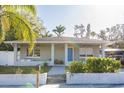 Charming home featuring a blue front door, a cozy front porch, and a freshly landscaped yard at 1305 20Th W St, Bradenton, FL 34205