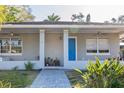 Inviting home with a bright blue front door, a brick walkway, and well-maintained landscaping at 1305 20Th W St, Bradenton, FL 34205