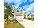 Charming two-story home with a two-car garage, complimented by a lush green lawn and mature landscaping at 13068 Oak Hill Way, Parrish, FL 34219