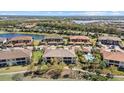 Scenic aerial view of community residences with a lake and a pool area at 13711 Messina Loop # 101, Bradenton, FL 34211