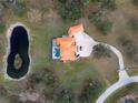Aerial shot of a home with an orange tile roof, circular driveway, and a kidney shaped pond at 1450 & 12001 Bern Creek Loop, Sarasota, FL 34240