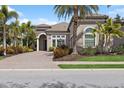 Beautiful home exterior with lush landscaping and a paver driveway at 14817 Secret Harbor Pl, Lakewood Ranch, FL 34202