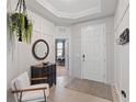 Welcoming entryway featuring neutral tile floors, modern light fixtures, a decorative table, and coat rack at 17108 Harvest Moon Way, Bradenton, FL 34211