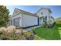 The side of a two-story home exhibits manicured landscaping, well-maintained lawn, and an appealing white exterior at 2309 Blue Mahoe Ln, Sarasota, FL 34240