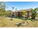 Charming home featuring meticulously maintained landscaping, decorative shrubbery, and mature palm trees at 2678 Rock Creek Dr, Port Charlotte, FL 33948