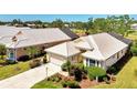 Aerial view of a home showcasing its tile roof, landscaped yard and proximity to golf course and water at 320 Bermuda Ct, Venice, FL 34293