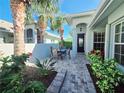 Inviting front courtyard with a seating area, lush landscaping, and tiled walkway at 321 Reclinata Cir, Venice, FL 34292