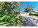 A beautiful home featuring lush landscaping, mature trees, and a spacious two-car garage at 51 Webb St, Osprey, FL 34229