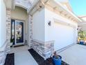 Welcoming front entry with stone detailing and a modern glass door, adjacent to the garage at 5277 Grove Mill Loop, Bradenton, FL 34211