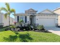 Charming single-Gathering home featuring lush green grass, beautiful landscaping, and a two-car garage at 5277 Grove Mill Loop, Bradenton, FL 34211