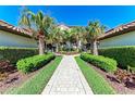 Paver walkway leading to the residence, surrounded by lush tropical landscaping at 5577 Palmer Cir # 203, Bradenton, FL 34211