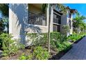 Close up of condo exterior featuring black metal railings and manicured tropical landscaping at 5695 Palmer Cir # 101, Bradenton, FL 34211