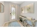 Light-filled foyer featuring decorative front door, stylish console table, and elegant wall art at 5931 Wake Forest Run # 104, Bradenton, FL 34211