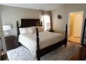 Cozy bedroom with a dark wood bed frame, neutral walls, and plush white carpet at 6709 Rock Bridge Ln, Ellenton, FL 34222