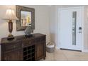 Entryway with lamp, mirror, fish decor and tiled floors adjacent to white front door with glass inset at 6804 Gulf Dr # 6804, Holmes Beach, FL 34217