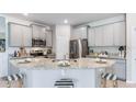 Modern kitchen with granite countertops, stainless steel appliances, breakfast bar, and ample cabinet space at 723 157Th E Ct, Bradenton, FL 34212