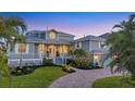 Charming two-story home with lush landscaping, a brick driveway, and a welcoming front porch at 810 Siesta Dr, Sarasota, FL 34242