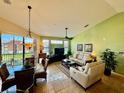 Open-concept living area with tile flooring, comfortable seating, and sliding doors leading to an outdoor balcony at 8351 38Th Street E Cir # 302, Sarasota, FL 34243