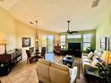 Bright living room featuring tile floors, ceiling fan, comfortable couches, and a dining area with a glass table at 8351 38Th Street E Cir # 302, Sarasota, FL 34243