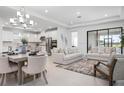 Bright, open-concept living and dining area featuring modern lighting and neutral decor at 11522 Trivio Ter, Palmetto, FL 34221