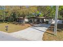 Charming single-story home with a spacious driveway, carport, and a well-manicured front yard at 124 E 119Th Ave, Tampa, FL 33612
