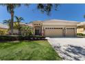 Charming home exterior with tile roof, 3-car garage, stone accents, and tropical landscaping at 13414 Goldfinch Dr, Lakewood Ranch, FL 34202