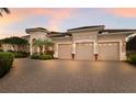 Beautiful home with a three-car garage featuring a brick-paved driveway and manicured landscaping at 13635 Legends Walk Ter, Lakewood Ranch, FL 34202