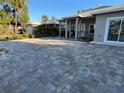 Paver driveway leading to a charming gray house with well-maintained landscaping and a black iron fence at 1534 25Th St, Sarasota, FL 34234