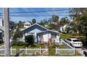 Quaint blue home with neat landscaping and a welcoming white picket fence at 1704 Ballard Park Dr, Bradenton, FL 34205