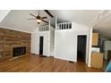 Bright living room featuring a vaulted ceiling, fireplace and a unique loft space at 1704 Ballard Park Dr, Bradenton, FL 34205