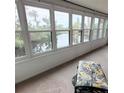 Sunroom with a wall of windows overlooking the backyard pond, bringing the beauty of the outdoors inside at 182 Pineneedle Dr # 182, Bradenton, FL 34210