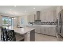 Modern kitchen with stainless steel hood, quartz countertops, and gray cabinetry at 2015 Bolsena St, Nokomis, FL 34275