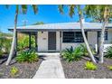 Inviting front entrance with modern door, stylish landscaping, and contemporary design elements at 2105 Hibiscus St, Sarasota, FL 34239