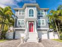 Charming two-story home with a red front door, white trim, and a brick paver driveway at 2300 Avenue B, Bradenton Beach, FL 34217