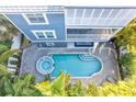 Aerial view of a pool and hot tub surrounded by a brick paver patio and palm trees at 2300 Avenue B, Bradenton Beach, FL 34217