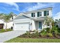 Charming two-story home with a neatly landscaped yard and a paver driveway leading to a two-car garage at 2616 Star Apple Way, Sarasota, FL 34240