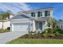 Charming two-story home with a neatly landscaped yard and a paver driveway leading to a two-car garage at 2616 Star Apple Way, Sarasota, FL 34240