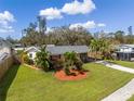 Charming single-story home featuring a well-maintained lawn, driveway, and lush tropical landscaping at 3458 Lalani Blvd, Sarasota, FL 34232