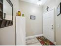 Well-lit hallway with a decorative mirror, white shelving unit, and patterned rug by the door at 4208 Central Sarasota Pkwy # 1422, Sarasota, FL 34238